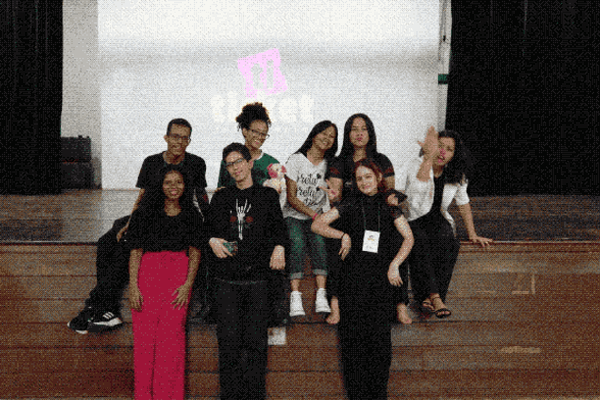 A equipe original do Ticket Inteligente e amigos reunidos no auditório, sorrindo e comemorando a conclusão do projeto e do ensino médio